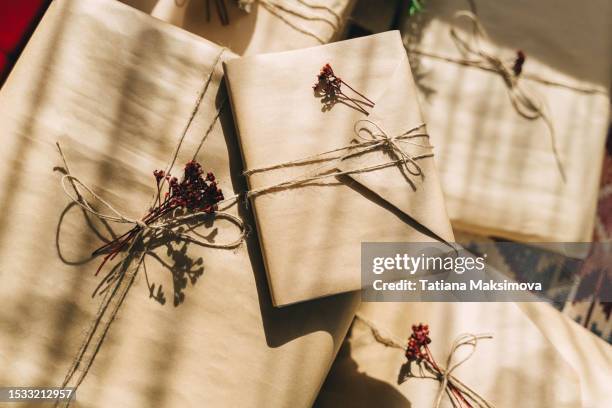 many christmas gift boxes wrapped in craft paper on the floor, top view. - birthday present stock pictures, royalty-free photos & images