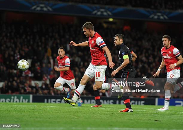 Aaron Ramsey chips the ball over Olympiacos goalkeeper Balazs to score the 3rd Arsenal goal during the UEFA Champions League Group B match between...