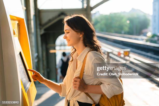 woman buying ticket from ticket machine on the station - germany train stock pictures, royalty-free photos & images