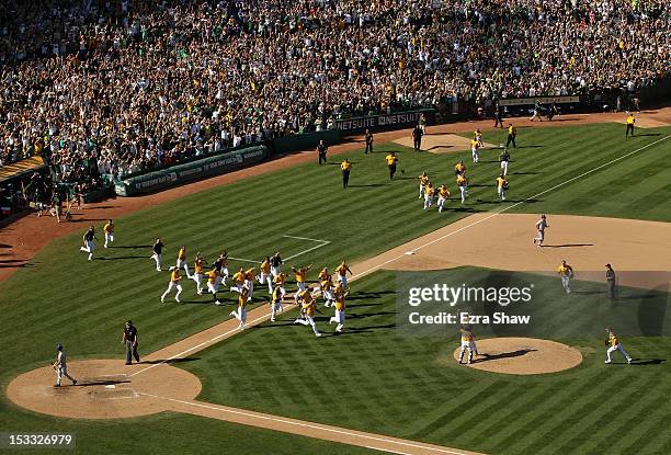 Grant Balfour and Derek Norris celebrate with the rest of the Oakland Athletics after they beat the Texas Rangers to win the American League West...