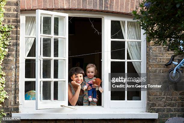 mother and child looking out a window - family looking at camera stock pictures, royalty-free photos & images