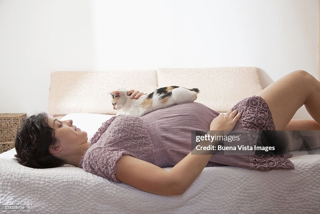 Pregnant woman in bed with her cat