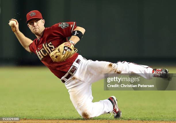 Infielder Aaron Hill of the Arizona Diamondbacks attempts to throw out Charlie Blackmon of the Colorado Rockies after he hit a single during the...