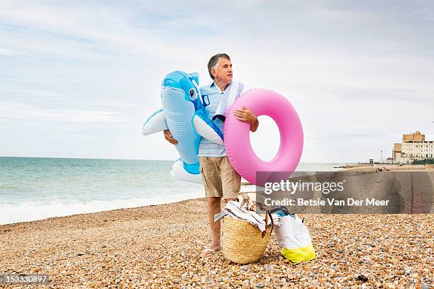 mature man waiting with beach accessoires. - toy animal stock photos et images de collection