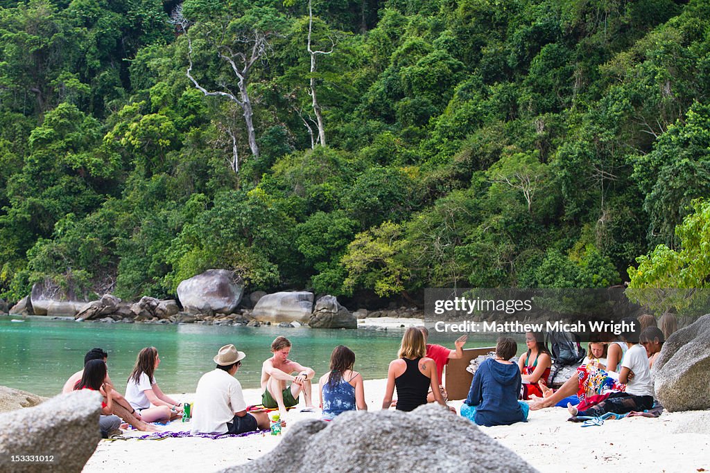 A group gathers on a Thai beach.