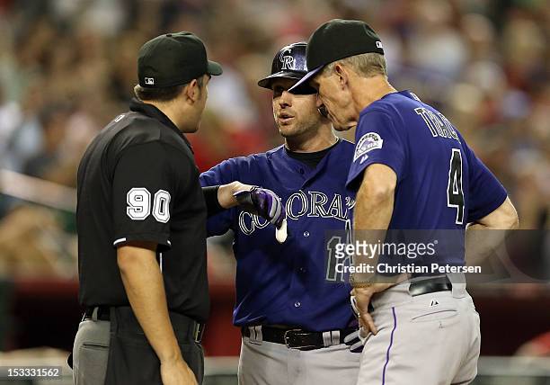 Andrew Brown and manager Jim Tracy of the Colorado Rockies argue with home plate umpire Mark Ripperger that Brown was hit in the hand by a pitch...