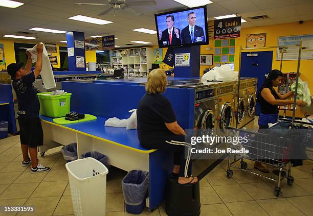 People at the Lavanderia coin laundry watch as U.S. President Barack Obama and Republican presidential candidate and former Massachusetts Governor...