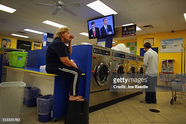 People at the Lavanderia coin laundry listen as U.S. President Barack Obama and Republican presidential candidate and former Massachusetts Governor...
