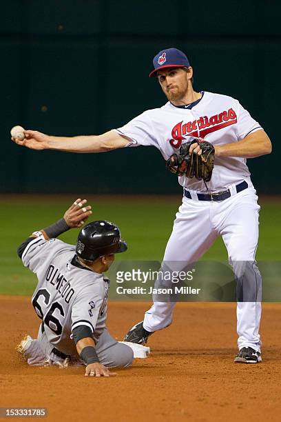 Shortstop Cord Phelps of the Cleveland Indians throws to first base for a double play as Ray Olmedo of the Chicago White Sox is out at second base...