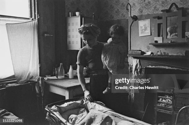 Mother looking after her children at home in a deprived area of Finsbury, London, 1952. Original Publication: Picture Post - 6142 - Finsbury Slums -...