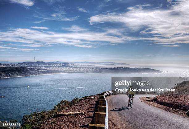 lone biker turning corner - bahía de san francisco fotografías e imágenes de stock