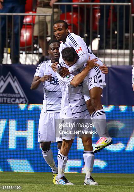 Andy O'Brien of the Vancouver Whitecaps FC hoists goal scorer Dane Richards in front of Gershon Koffie against Chivas USA during their MLS game...