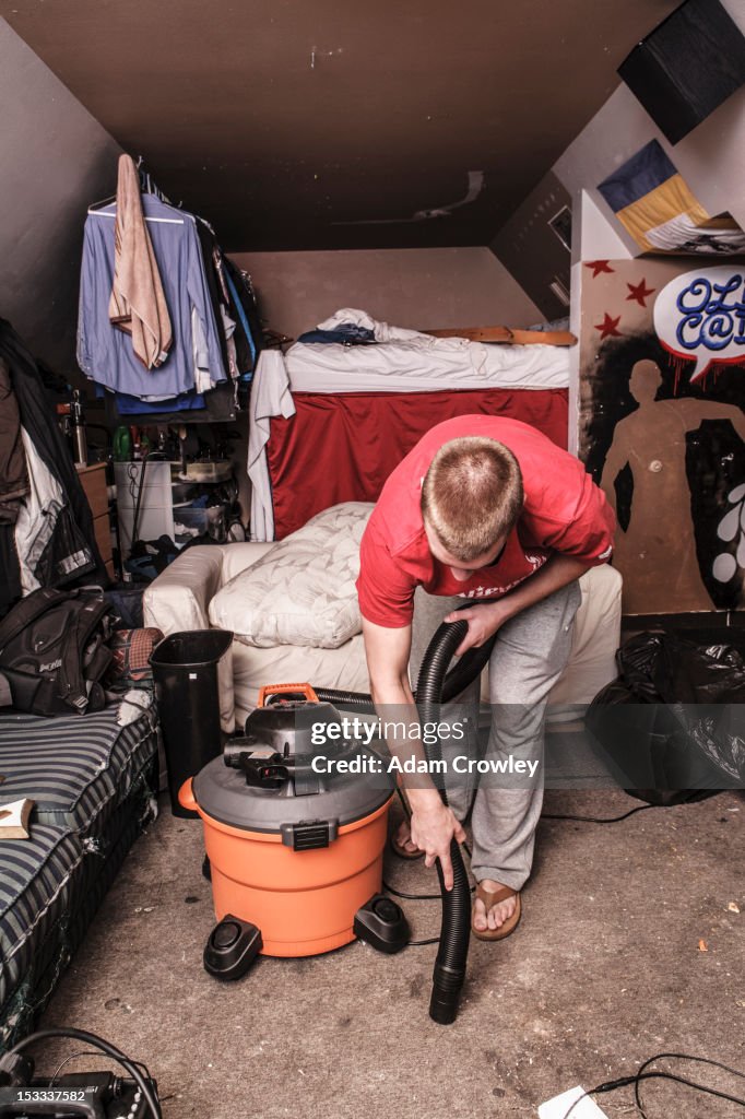 Caucasian man vacuuming floor