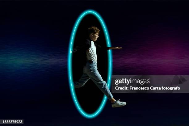 man jumping inside neon metaverse portal - surreal door stock pictures, royalty-free photos & images