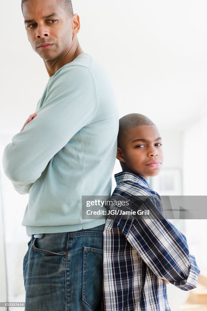Stubborn father and son standing back to back