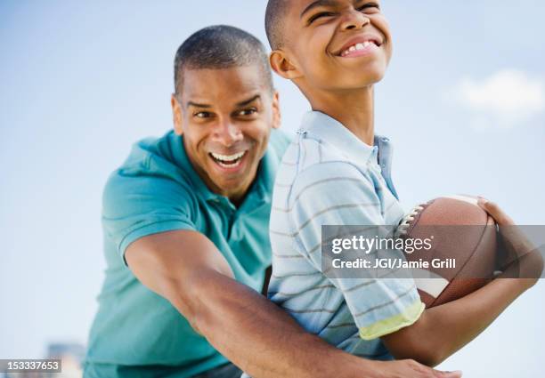 father and son playing football - tackle american football player stockfoto's en -beelden