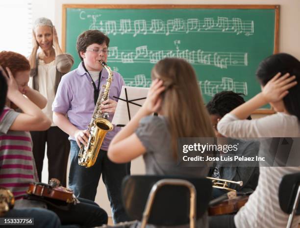 student playing saxophone badly - sad musician stock pictures, royalty-free photos & images