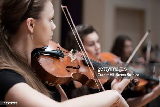 woman playing violin in orchestra - violinist stock pictures, royalty-free photos & images
