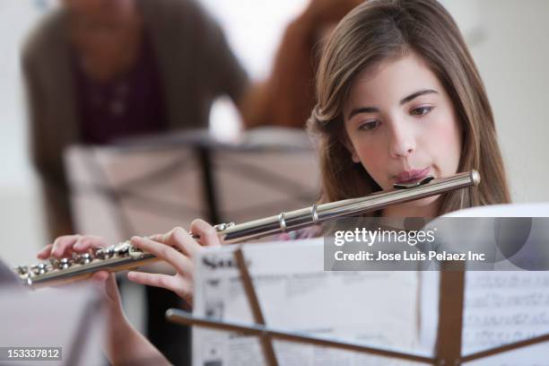 caucasian student playing flute in music class - leggio-per-spartiti-musicali foto e immagini stock