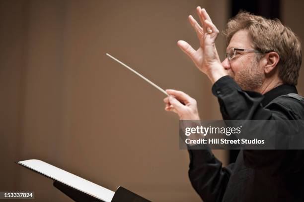 conductor leading orchestra - orchestra foto e immagini stock