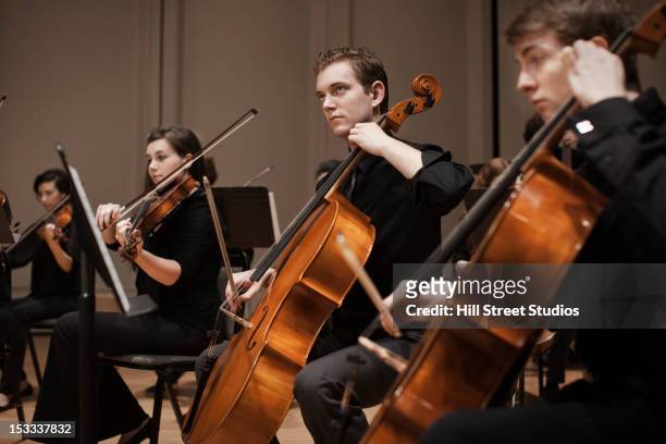 musicians performing in orchestra - orchestra stock-fotos und bilder