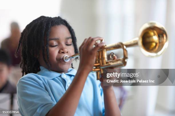 black student playing trumpet in music class - trumpet fotografías e imágenes de stock