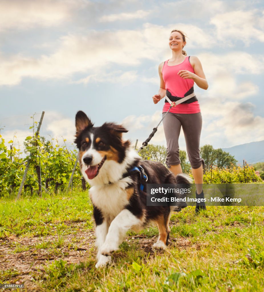 Caucasian woman running with dog