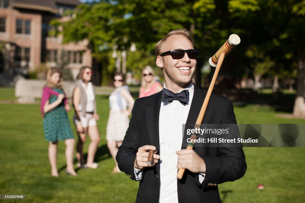 Smiling Caucasian man holding croquet mallet