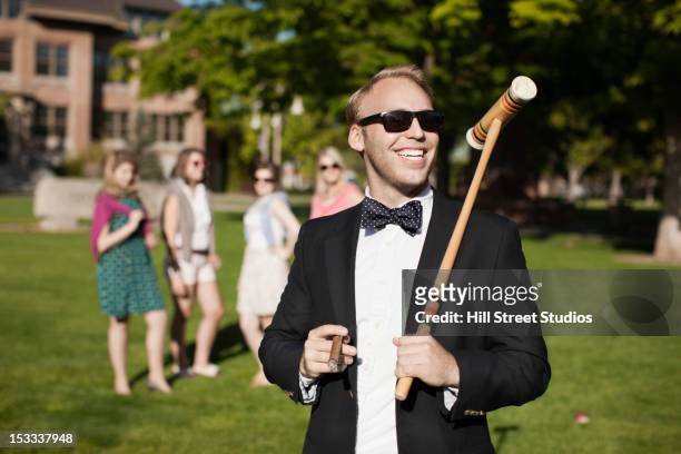 smiling caucasian man holding croquet mallet - ステータス ストックフォトと画像