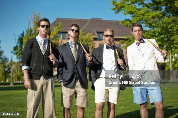 caucasian man standing together with croquet mallets - privilegien stil stock-fotos und bilder