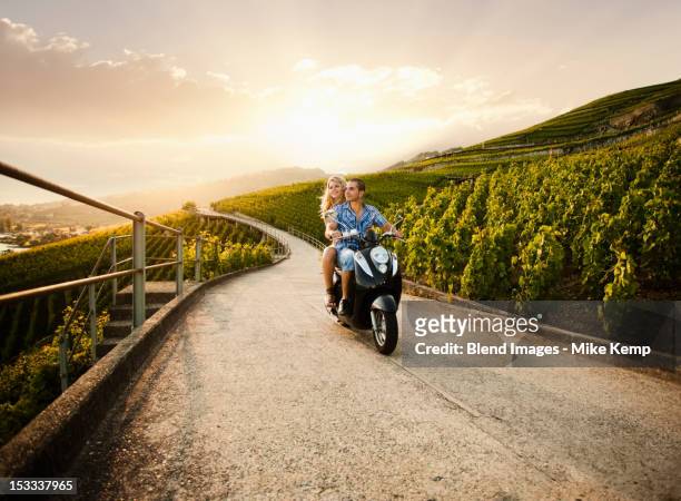 couple riding scooter in vineyard - girl riding scooter stock pictures, royalty-free photos & images