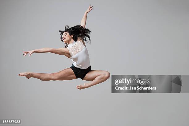 graceful caucasian ballet dancer in mid-air - show of strength stock-fotos und bilder