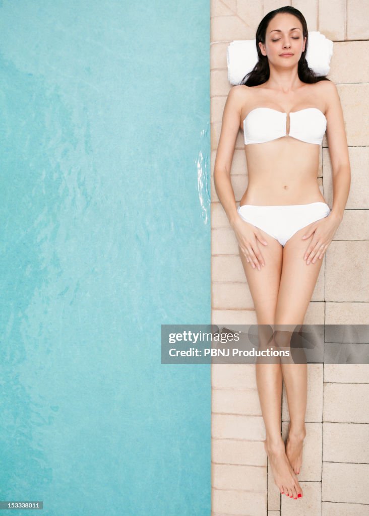 Caucasian woman lying at poolside