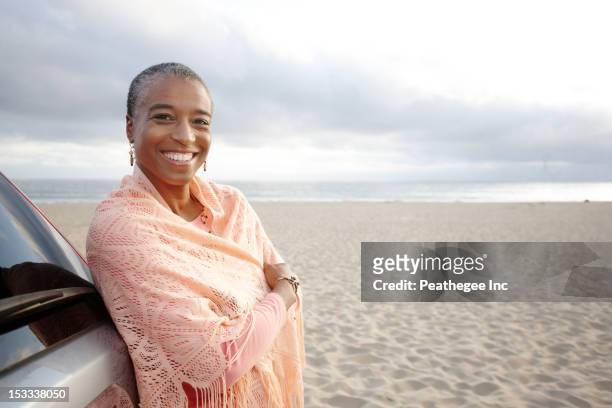 black woman in shawl standing on beach - woman in a shawl stock pictures, royalty-free photos & images