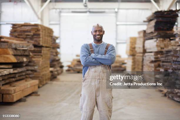 black worker in lumber warehouse - bib overalls 個照片及圖片檔