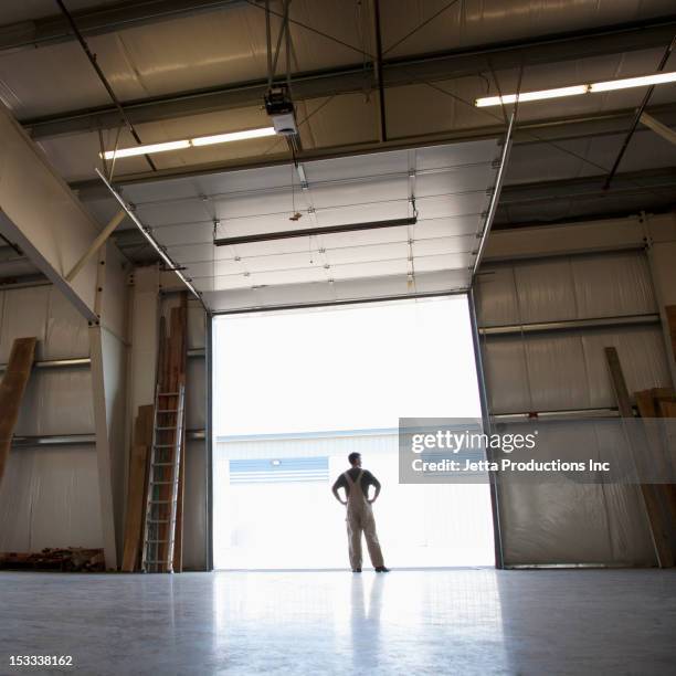 caucasian worker in empty warehouse - factory door stock pictures, royalty-free photos & images