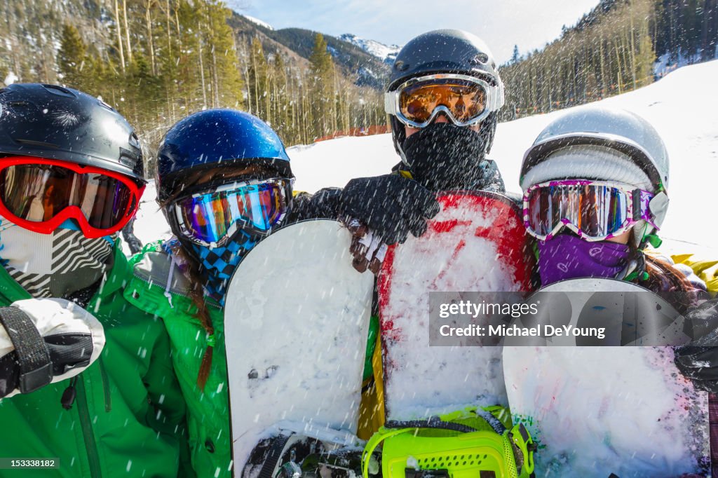 Teenagers snowboarding together