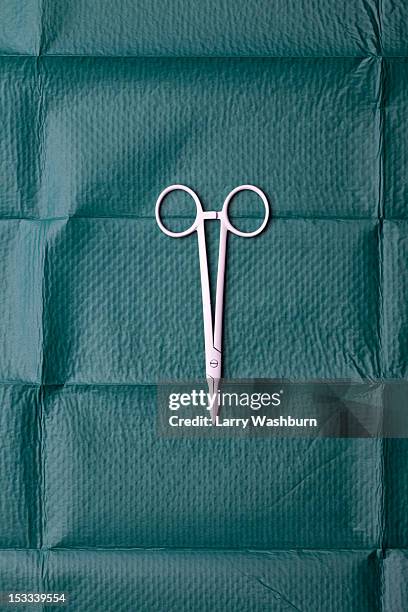 a pair of surgical scissors on a surgical drape - equipamento cirúrgico imagens e fotografias de stock
