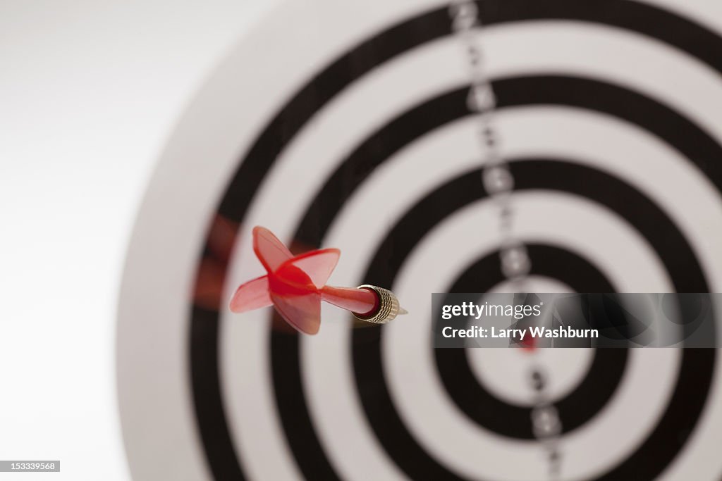 Rear view of a dart flying towards the bull's eye of a target