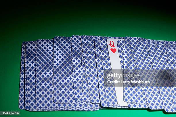 cards fanned out face down, except for one, the queen of hearts - gambling table 個照片及圖片檔