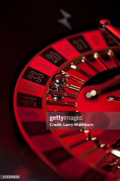 a stationary roulette wheel with the ball on number 33 - roulette photos et images de collection