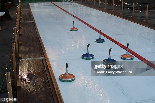 curling stones on a curling sheet - curling stock-fotos und bilder