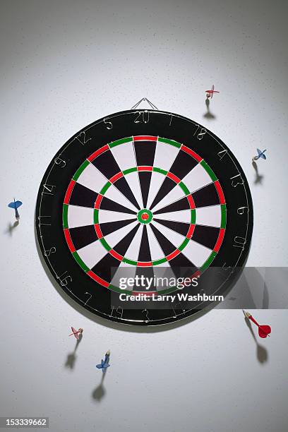 darts stuck in a wall all around a dartboard - off target stock pictures, royalty-free photos & images