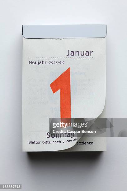 a german daily calendar showing new year's day with curled up page corner - calendrier photos et images de collection