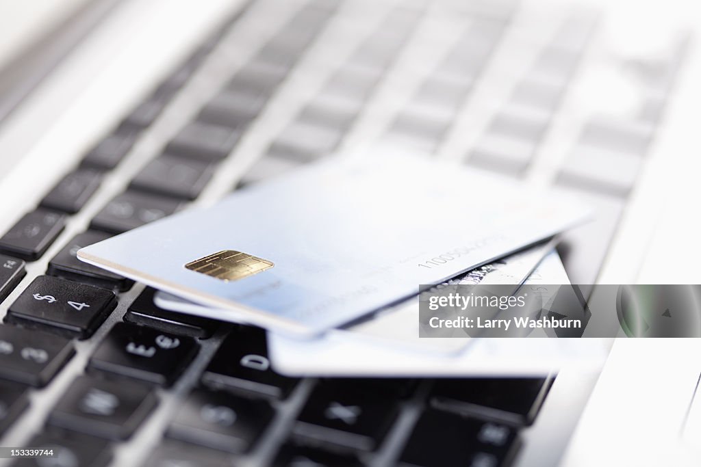 Three credit cards lying on a laptop keyboard