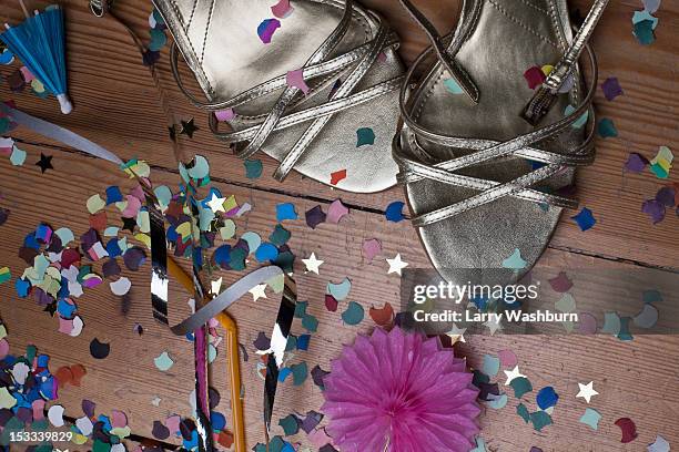 metallic strappy heels, confetti and streamers littering a hardwood floor - series finale party stock pictures, royalty-free photos & images