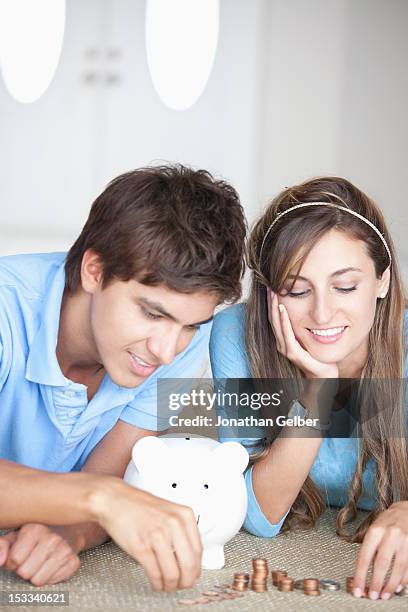 a young cheerful couple counting coins on the floor - 2 cents stockfoto's en -beelden