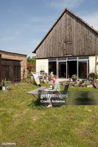 a woman using a laptop and having breakfast in her backyard - man-sitting-on-grass-using-laptop-elevated-view stock pictures, royalty-free photos & images