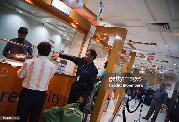 Bank teller serves a customer at a counter in a JS Bank Ltd. Bank branch in Karachi, Pakistan, on Wednesday, Oct. 3, 2012. Pakistan’s JS Bank, the...