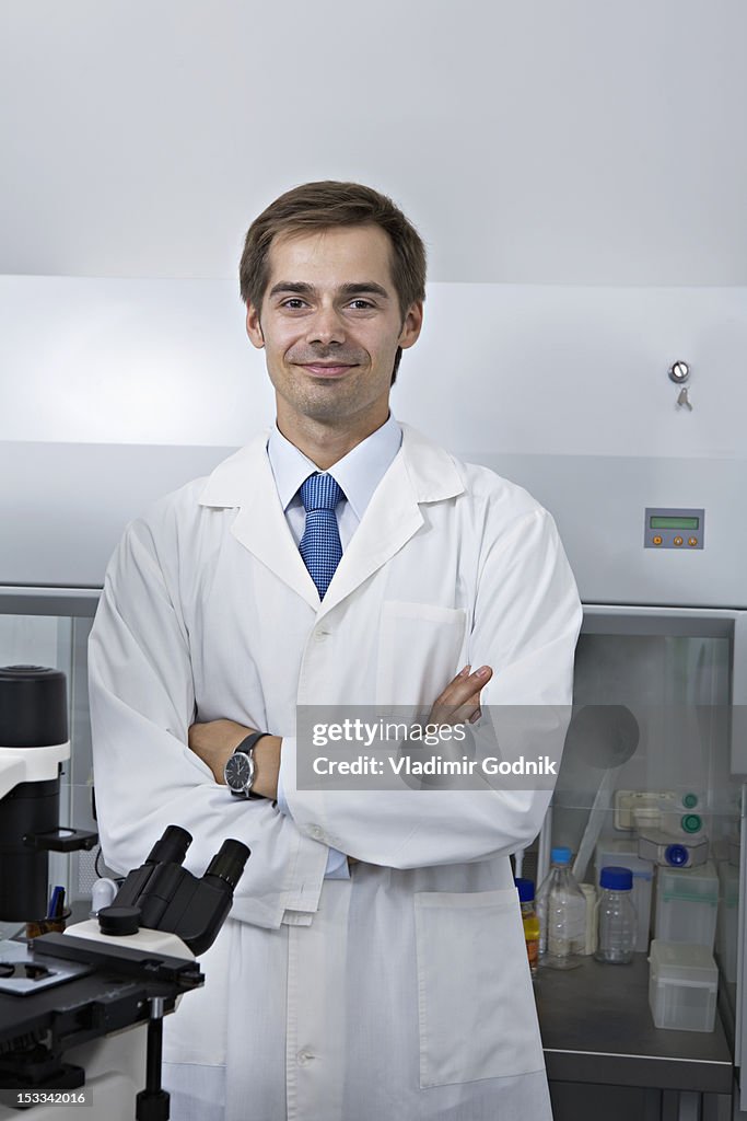 A smiling research technician standing in a research lab